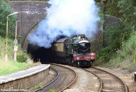 Steam train emerging from tunnel